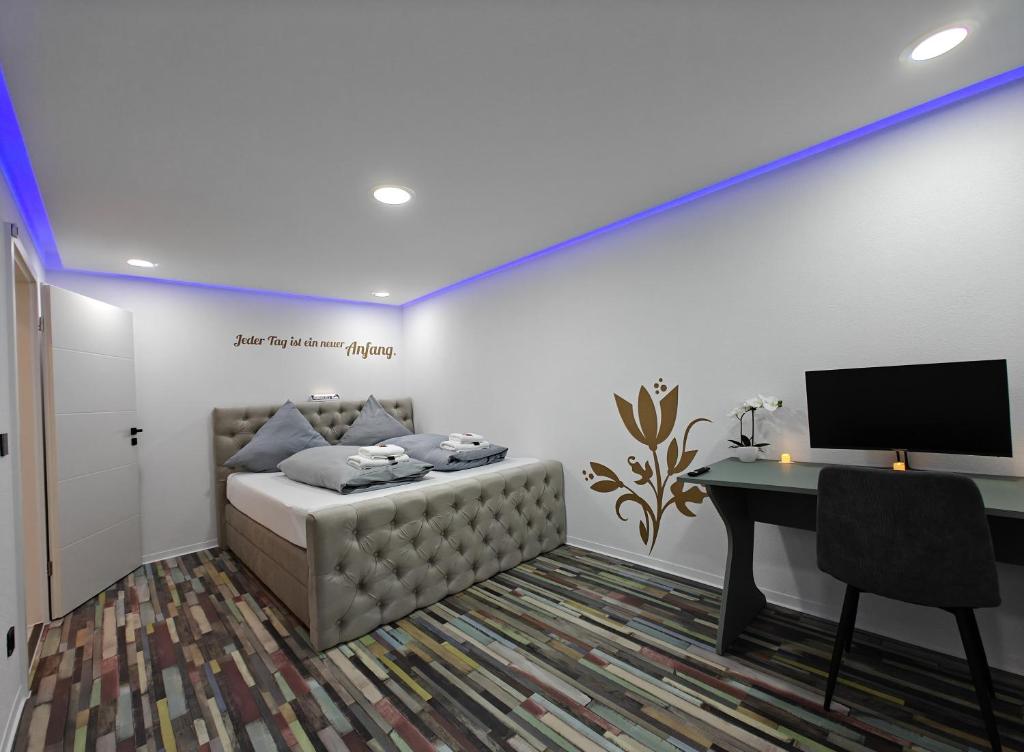 una habitación con una cama y un escritorio con una computadora en Modern Apartments Neuburg 9, en Neuburg an der Donau