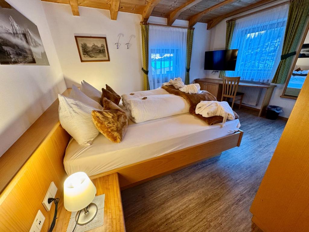 sypialnia z łóżkiem i biurkiem w pokoju w obiekcie Residence Palmai w mieście Ortisei