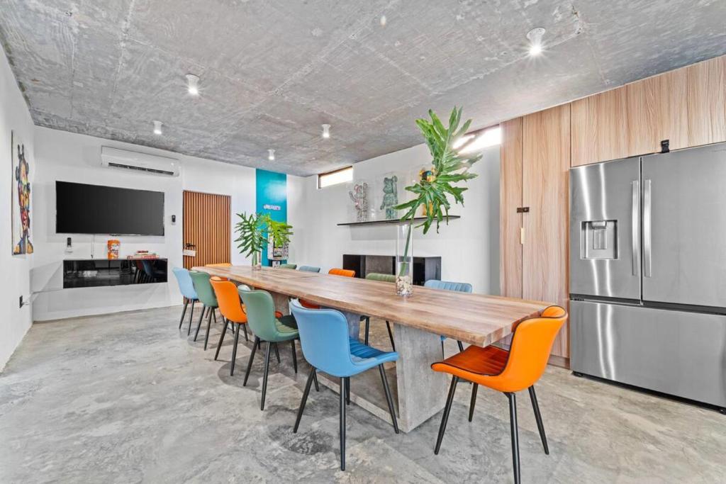 une grande cuisine avec une grande table et des chaises en bois dans l'établissement Featuring a breathtaking infinity pool and a beach tennis court, à Loiza