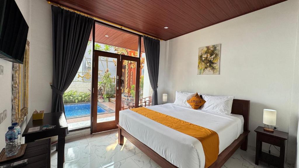 Un dormitorio con una cama y una ventana grande. en Langit Guest House Canggu, en Canggu
