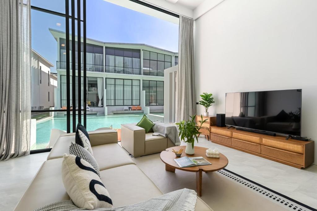 a living room with a couch and a tv at Zen Style Pool Access Townhouse in Nathon Bay