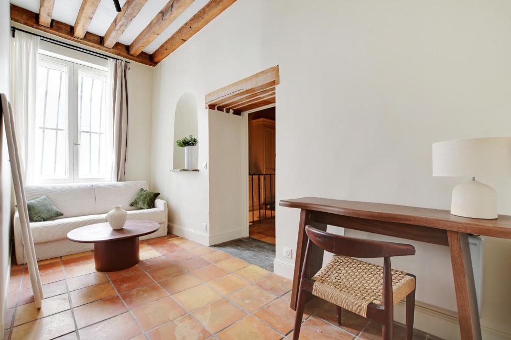 un salon avec une table et un canapé dans l'établissement Appartement Triplex à Saint-Germain-des-Prés, à Paris