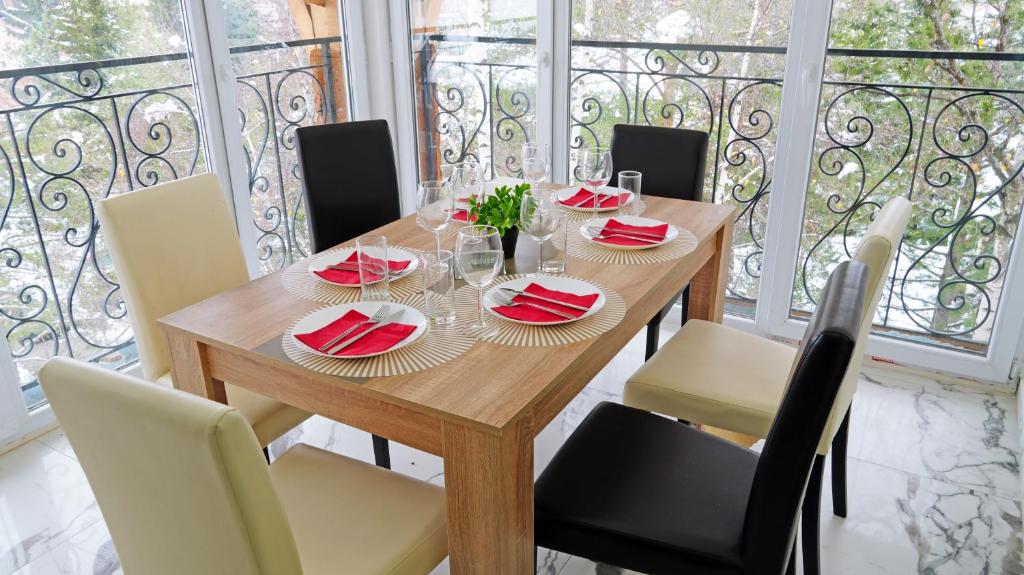 a wooden table with red napkins and chairs on a balcony at Apartments Bramar in Zlatibor