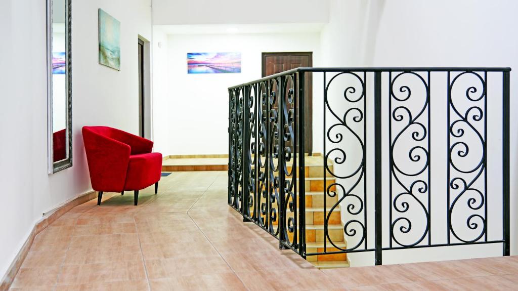 a red chair and a staircase in a room at Apartments Bramar in Zlatibor
