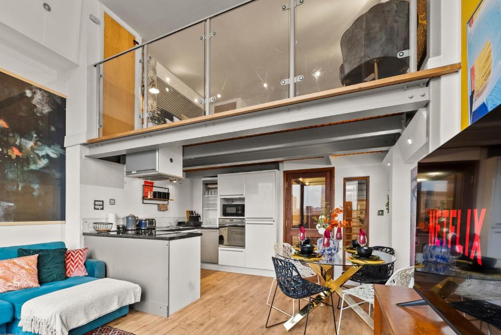 ein Wohnzimmer mit einer blauen Couch und einer Küche in der Unterkunft 30 Percent OFF - The Artists Duplex of Central Nottingham in Nottingham