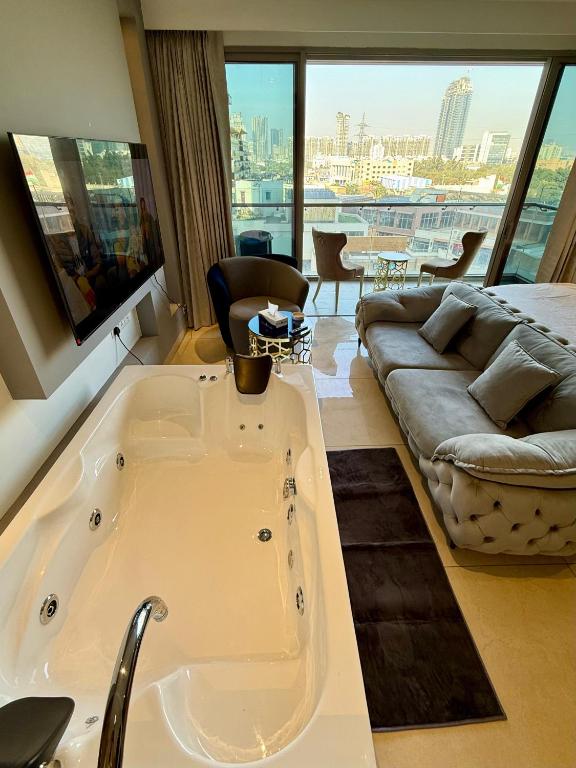 a large bath tub in a room with a couch at New Private Turkish Luxe Jacuzzi Studio in Gurgaon