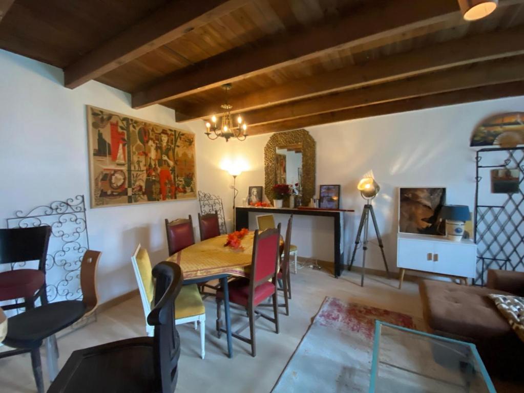 a living room with a dining room table and chairs at La Grange des zarts in Champagné-le-Sec