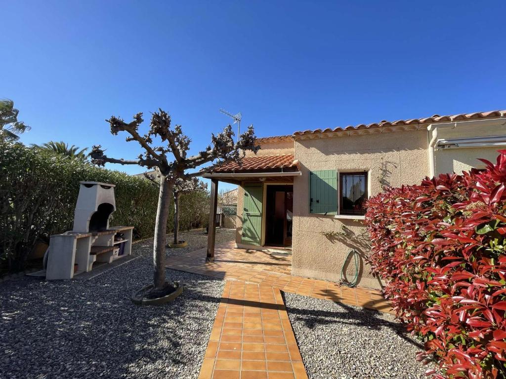une maison avec un arbre à côté d'une passerelle dans l'établissement Maison 3 pièces mezzanine 6 couchages ST CYPRIEN PLAGE SC390-028, à Saint Cyprien Plage
