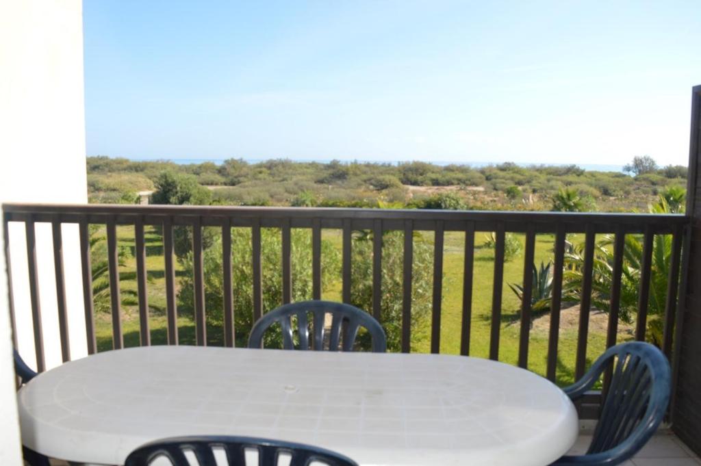 une table blanche et des chaises sur un balcon dans l'établissement SAINT CYPRIEN - Appartement 3 PIECES 6 Personnes SC060-106A, à Saint Cyprien Plage
