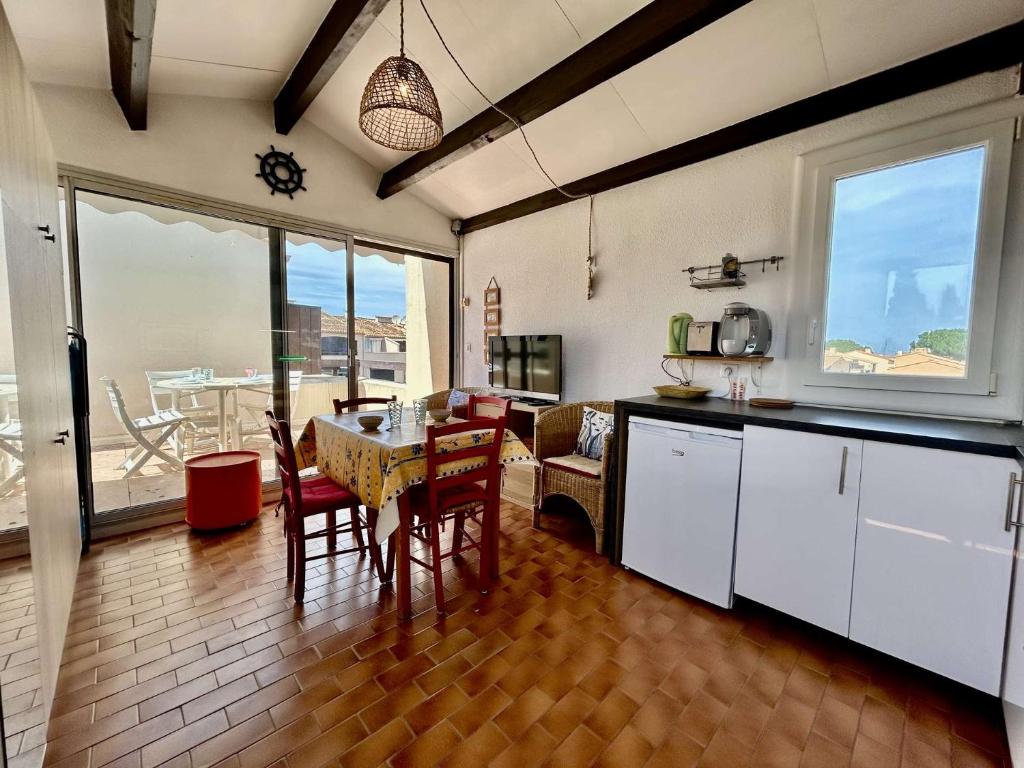 une cuisine avec une table et des chaises ainsi qu'une salle à manger dans l'établissement Appartement studio cabine 4 couchages ST CYPRIEN PLAGE SC380-F274, à Saint Cyprien Plage
