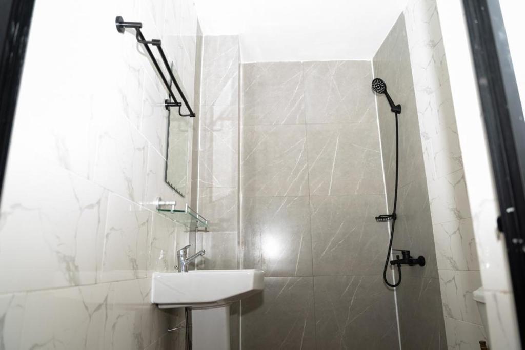 a bathroom with a sink and a shower at Airport INN Hotel in Lomé