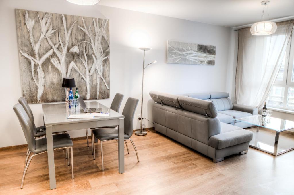 een woonkamer met een bank en een tafel bij Residence Aparthotel in Szczecin