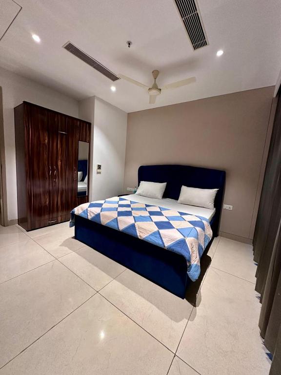 a bedroom with a bed with a blue and white blanket at Luxe 2 BHK with Stunning Views in Gurgaon