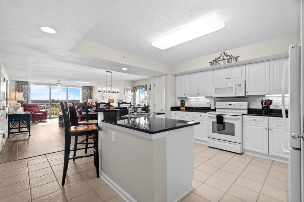 a kitchen with white cabinets and a kitchen island with a counter top at Yacht Club Villas 1-505 - Marina View in Myrtle Beach