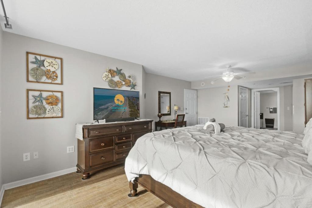 a bedroom with a bed and a dresser with a television at Yacht Club Villas 1-505 - Marina View in Myrtle Beach