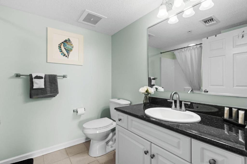 a bathroom with a sink and a toilet and a mirror at Yacht Club Villas 1-505 - Marina View in Myrtle Beach