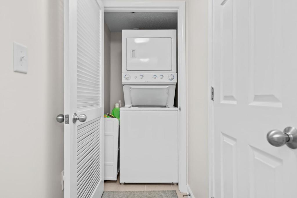 a kitchen with a washer and dryer on top of a refrigerator at Yacht Club Villas 1-505 - Marina View in Myrtle Beach