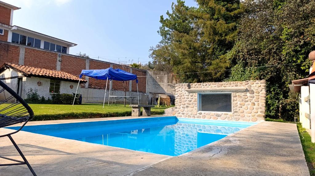 una piscina in un cortile accanto a una casa di Finca 7 Reyes Casa con alberca a Villa del Carbón