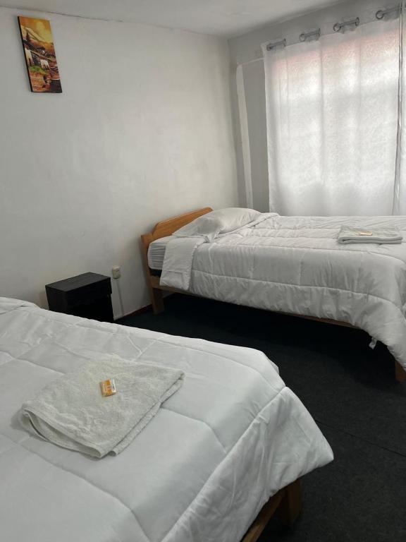 a hotel room with two beds and a window at ENEDE HOSTEL in Cusco