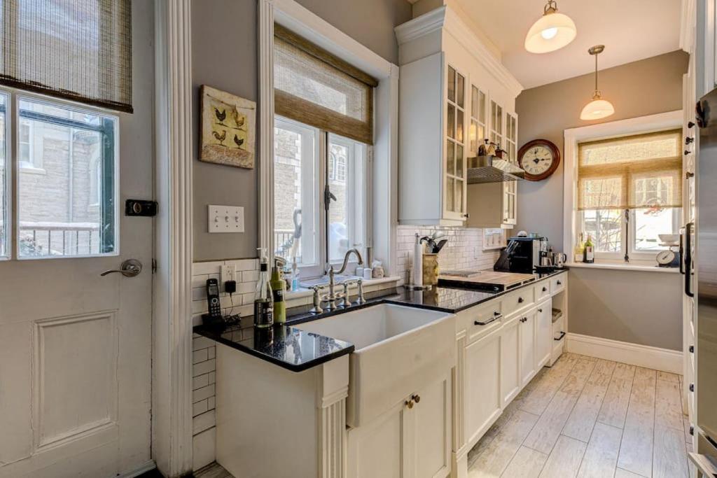 a kitchen with white cabinets and a sink and a window at 2002 Les Immeubles Charlevoix - 2002 - Le Parloir in Quebec City