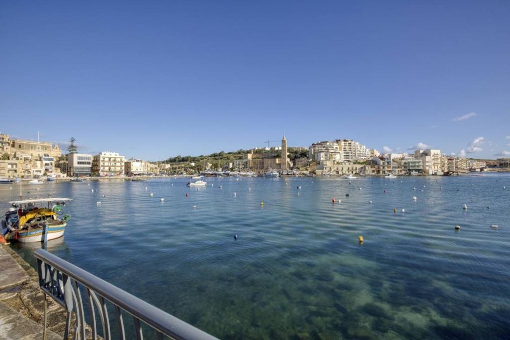 duży zbiornik wody z miastem w tle w obiekcie Seaview,beautiful 3br Apt 3 w mieście Marsaskala