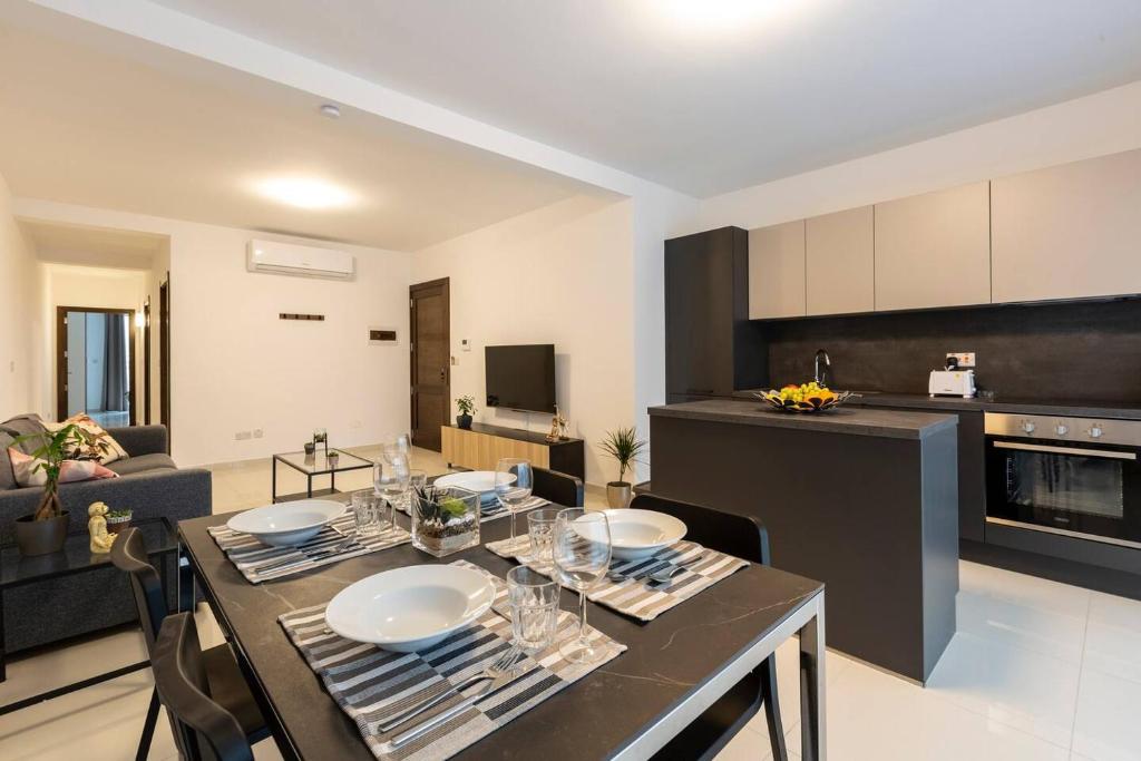 a kitchen and living room with a table and chairs at Beautiful Modern Central 2BR Apt in Taʼ Xbiex