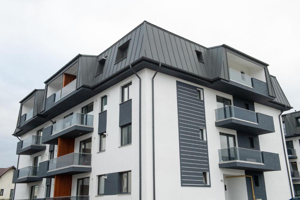 un edificio de apartamentos blanco con techo negro en Celine Apartments, en Piatra Neamţ