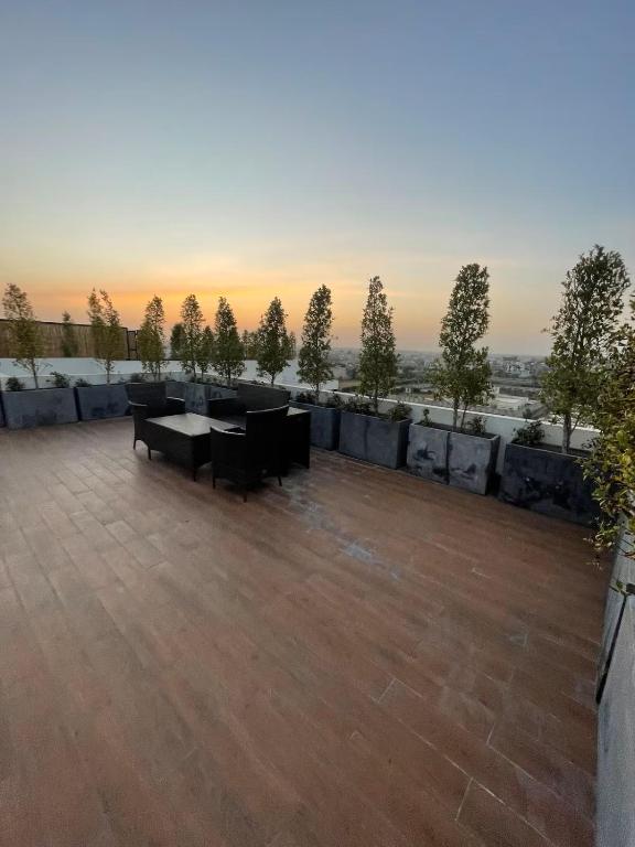 a patio with a table and chairs on a roof at Zameen Opal in Lahore