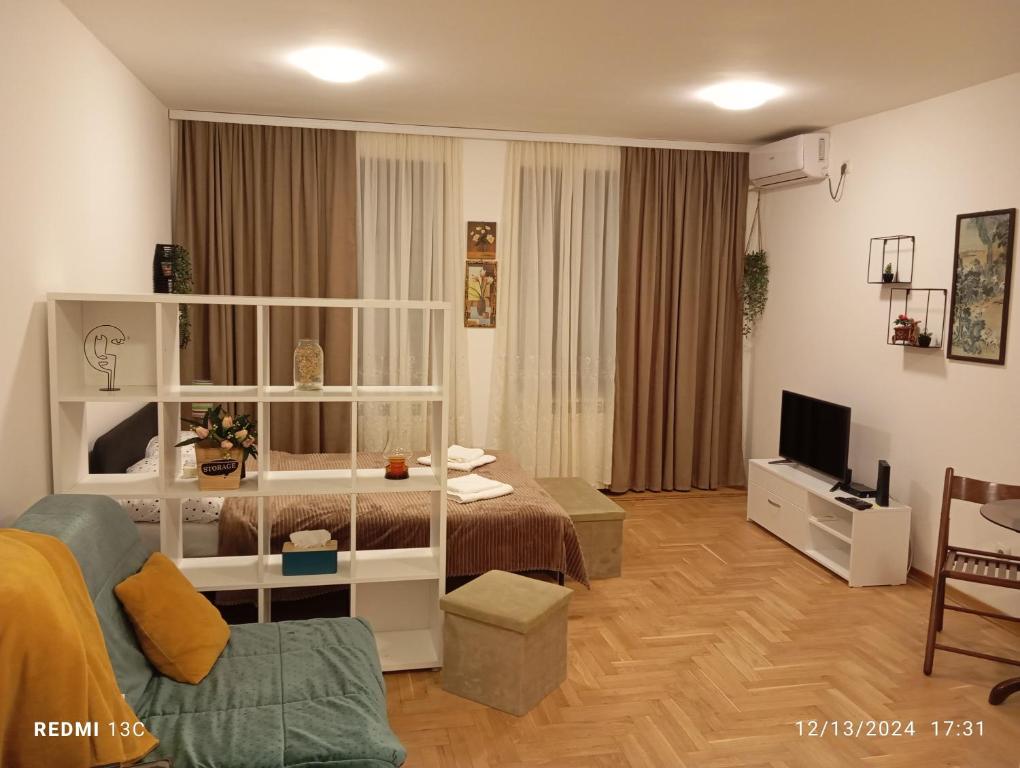 a living room with a bed and a television at Apartman Vuk in Obrenovac