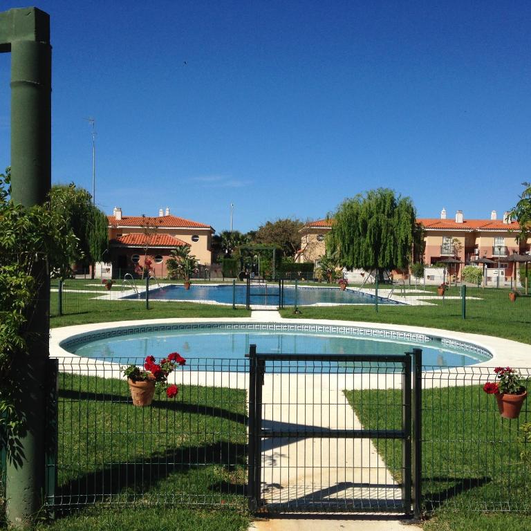 a swimming pool in a park with a fence at Divi Apartments Costa Ballena in Costa Ballena