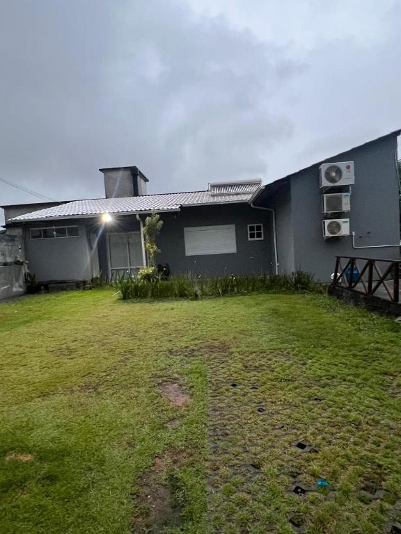 a house with a grass yard in front of it at Casa familiar - Refúgio Climatizado in Florianópolis