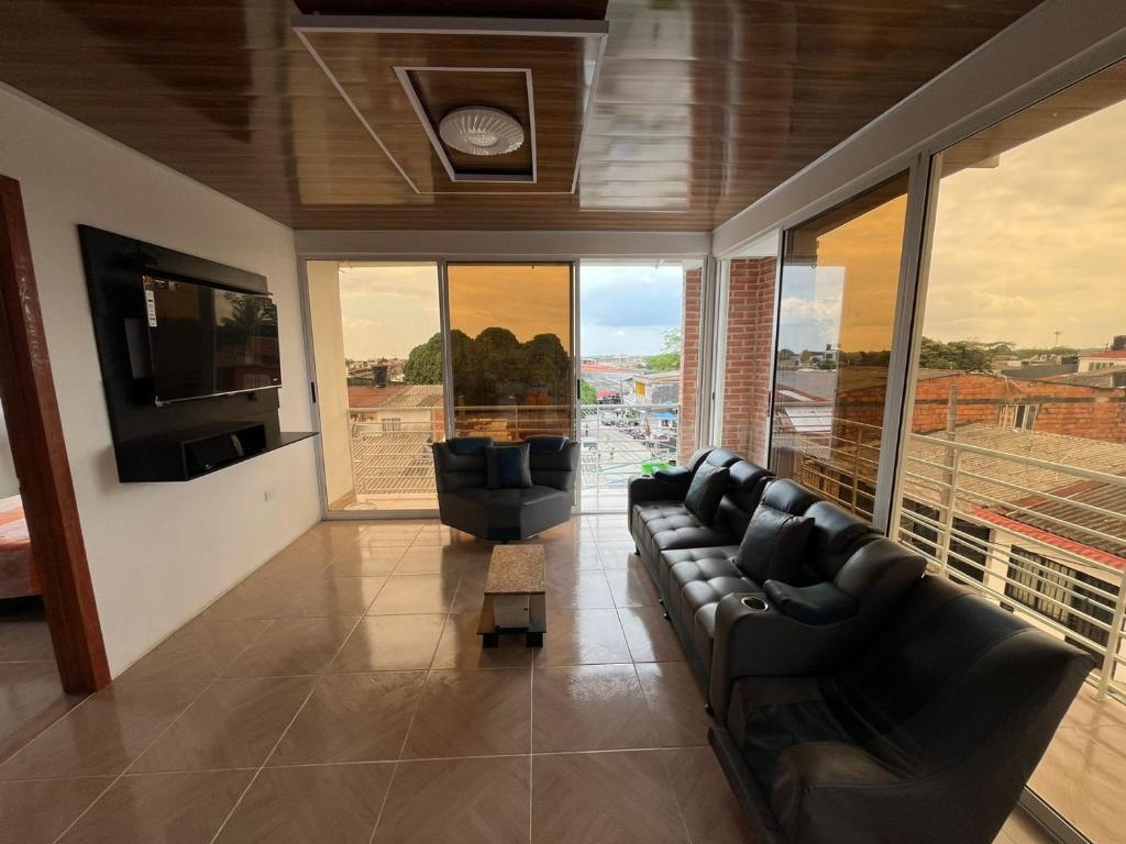 un soggiorno con divani, TV e ampie finestre di Hermoso Apartamento, comodo y fresco ad Acacías