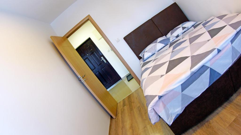 a bedroom with a bed with a mirror next to it at Apartments Bramar in Zlatibor
