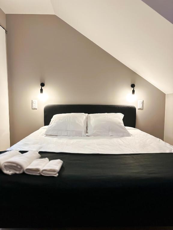 - un lit avec des draps blancs et 2 serviettes dans l'établissement La chambre graine de coton, à Amiens