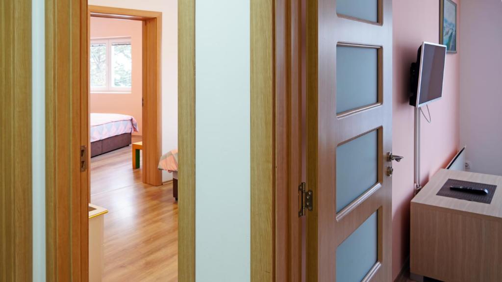 a door leading into a room with a bedroom at Apartments Bramar in Zlatibor