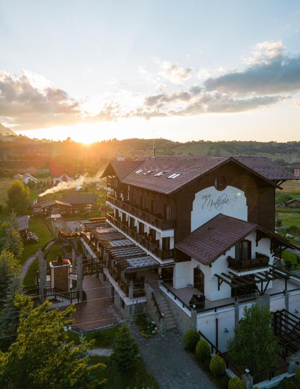 an aerial view of a building with the sunset in the background at Pensiunea Casa Nostalgia in Bran