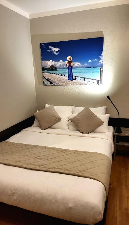 a bedroom with a bed with a picture of a beach at Apartment mit Balkon am Rhein in Koblenz