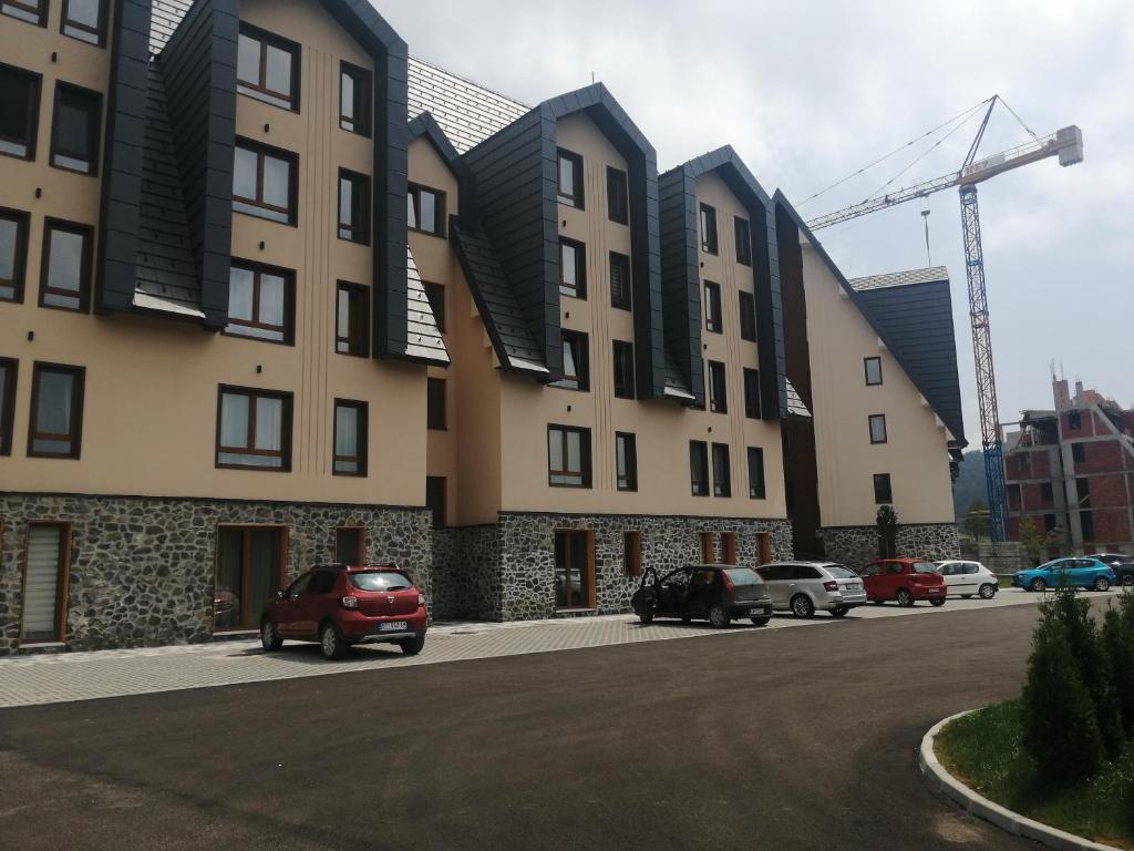 een gebouw met auto's geparkeerd op een parkeerplaats bij Divčinova1 Reset A2 in Divčibare