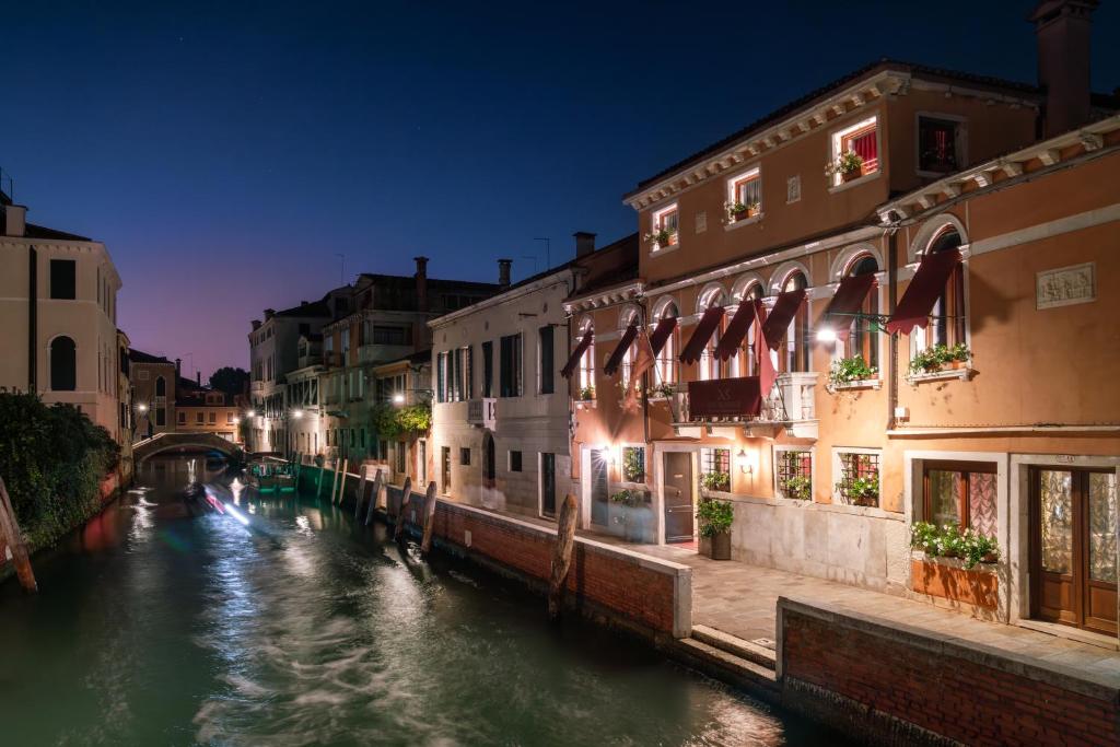 a canal with buildings and a bridge at night at Excess Venice Boutique Hotel & Private Spa - Adults Only in Venice