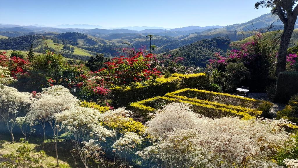 a garden with flowers and mountains in the background at Pousada Quinta da Serra in Cunha