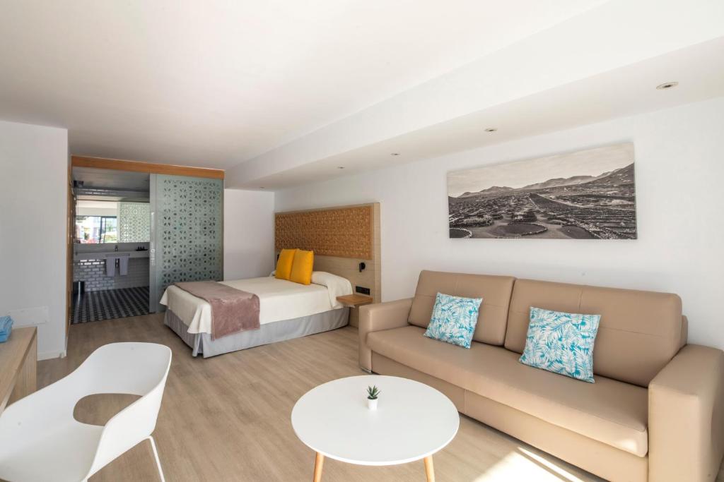 a hotel room with a couch and a bed at Oasis Lanz Beach Mate in Costa Teguise