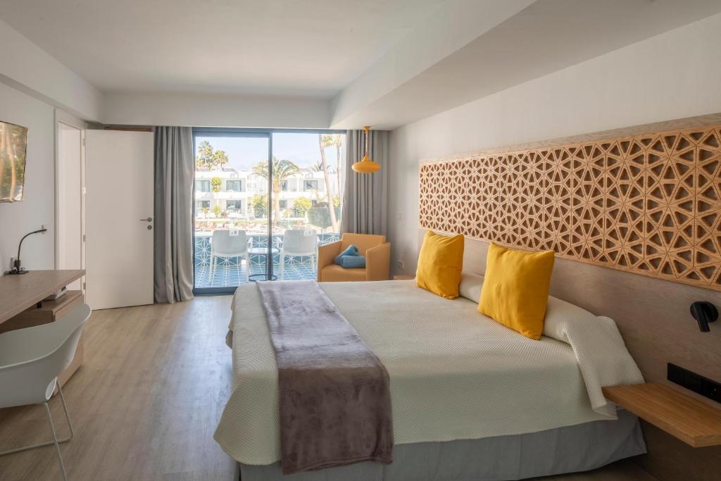 a hotel room with a large bed and a balcony at Oasis Lanz Beach Mate in Costa Teguise