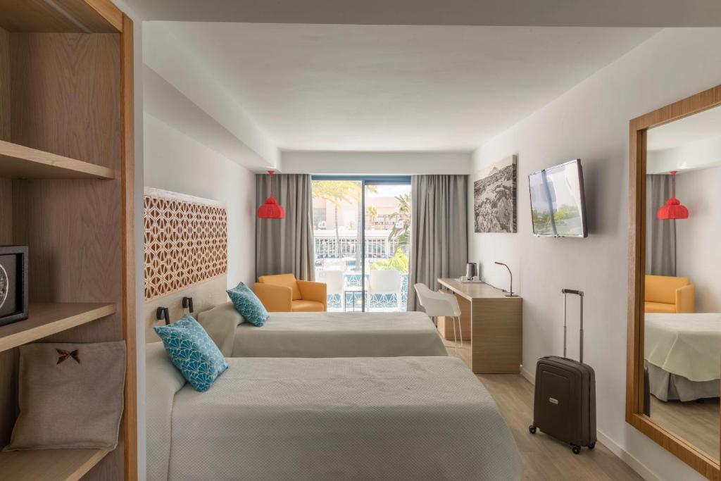 a hotel room with two beds and a sink at Oasis Lanz Beach Mate in Costa Teguise