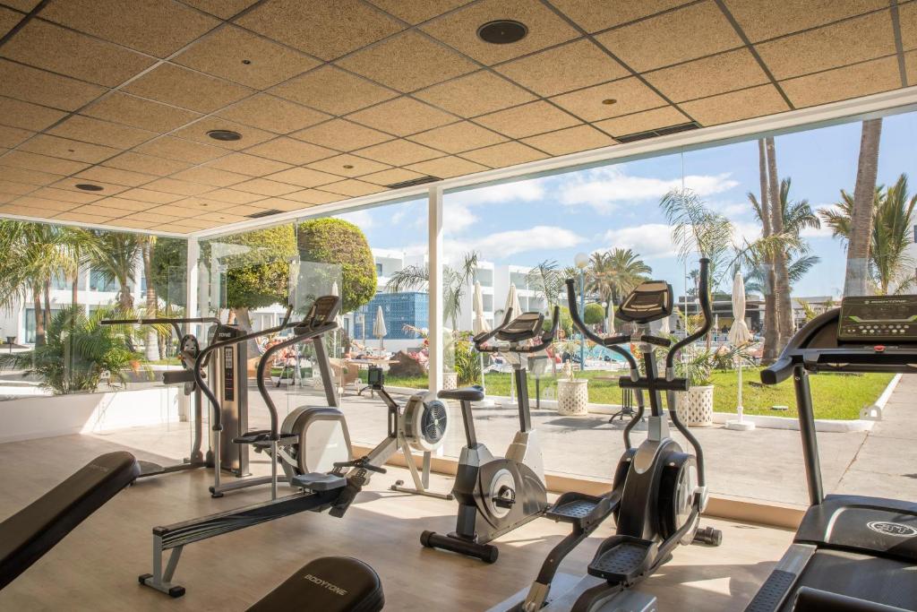 a gym with cardio machines and a large window at Oasis Lanz Beach Mate in Costa Teguise