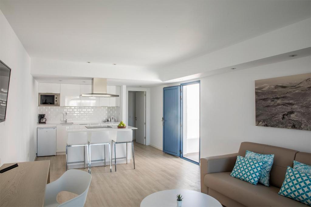 a living room and kitchen with a couch and a table at Oasis Lanz Beach Mate in Costa Teguise