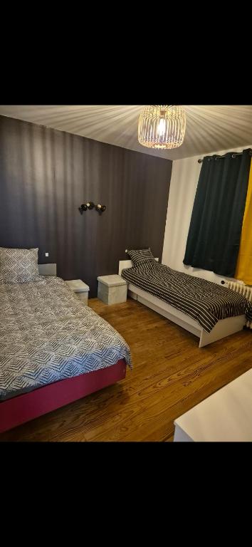 une chambre avec deux lits et un lustre dans l'établissement Chambre à louer, à Fécamp