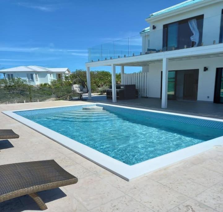 a swimming pool in front of a house at Las Brisas Azules in Providenciales