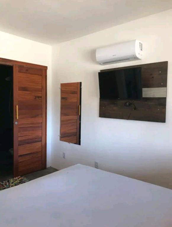 a bedroom with a bed and a tv on the wall at Chales Villa assu in Amontada