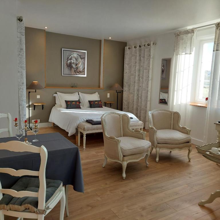- une chambre avec un grand lit, des chaises et des tables dans l'établissement La Ferme du BoisDieu, à Avallon