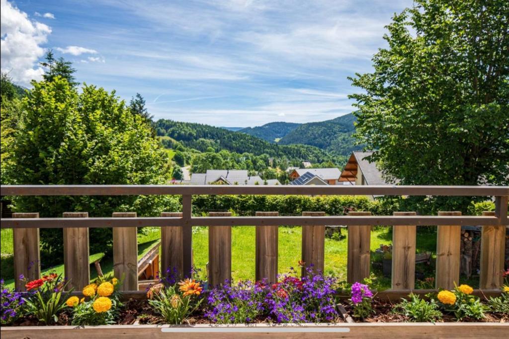une clôture en bois avec des fleurs dans un jardin dans l'établissement Les Roses du Vercors Appartement, à Villard-de-Lans